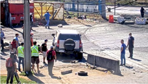 Trabajador eventual John Cuevas utilizando el sistema de enganche trasero de su vehículo particular marca Hummer H3, para trasladar material de concreto para barricadas